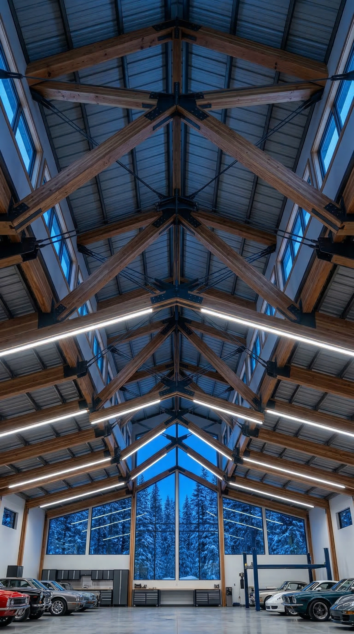 Low angle interior view of massive clear span roof trusses illuminating a completely open custom shop floor plan in the East Kootenays.